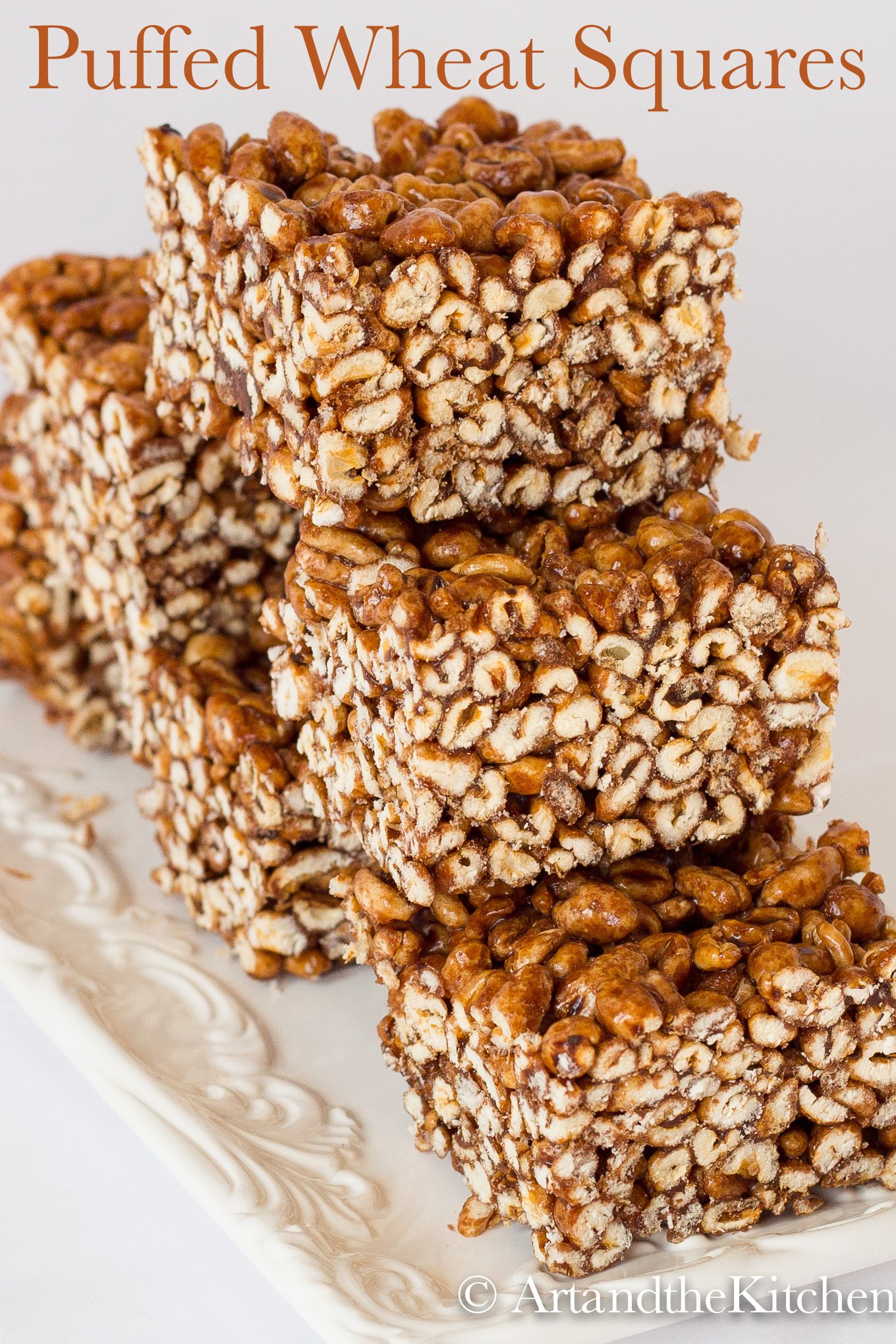 Stack of squares made of puffed wheat on white plate.