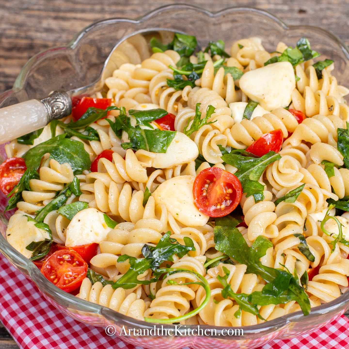 Rotini pasta tossed together with bocconcini, cherry tomatoes, arugula, and fresh basil.