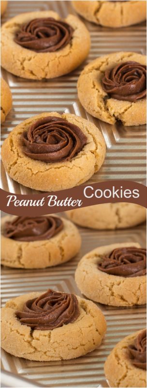 A baking sheet filled with peanut butter cookies topped with a dollop of whipped chocolate.