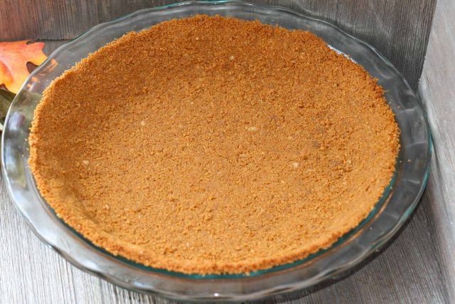 Pie crust made with gingersnaps in a glass pie plate.