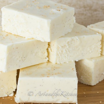 Stack of squares of white fudge made with eggnog flavor.