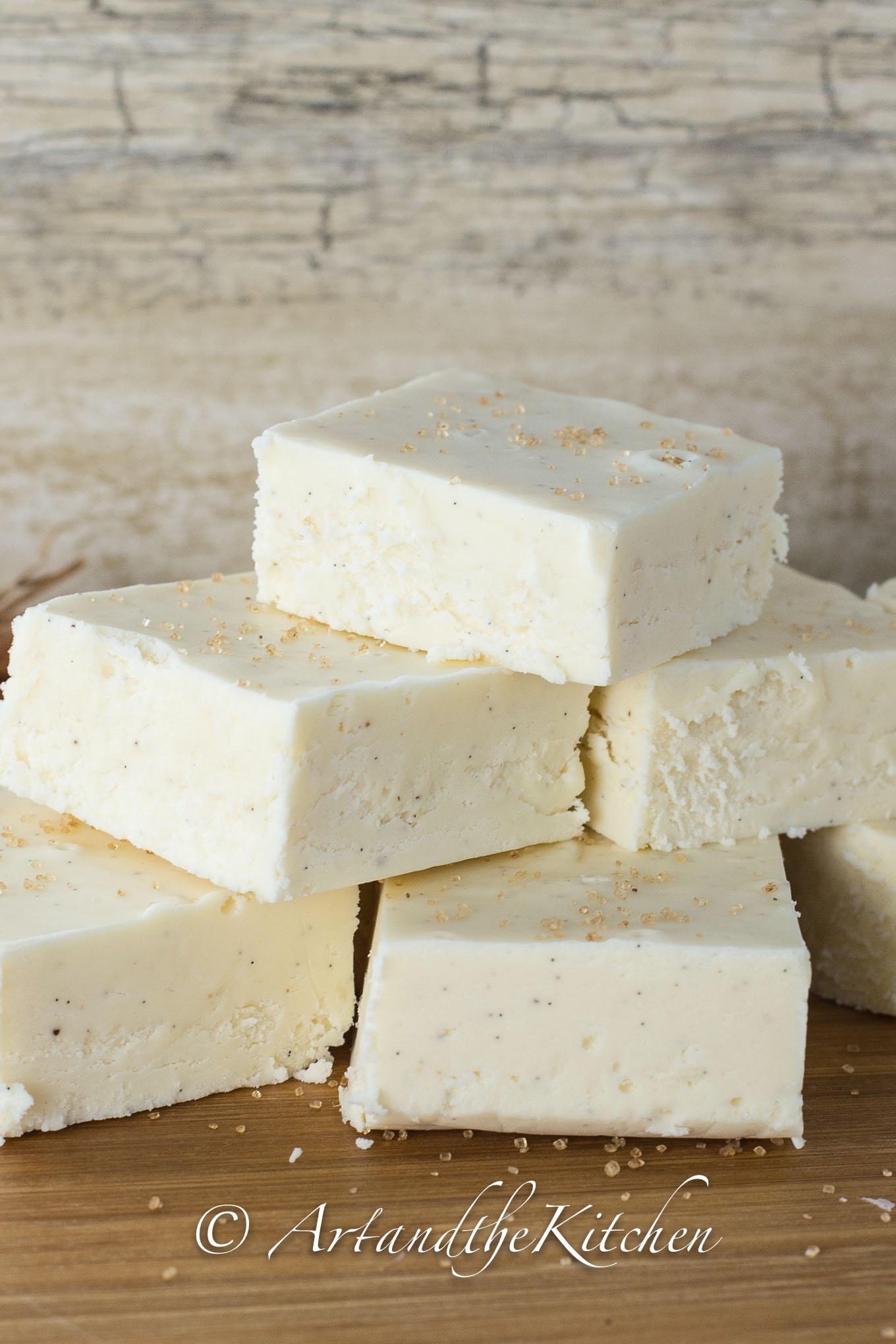 Stack of squares of white fudge made with eggnog flavor.