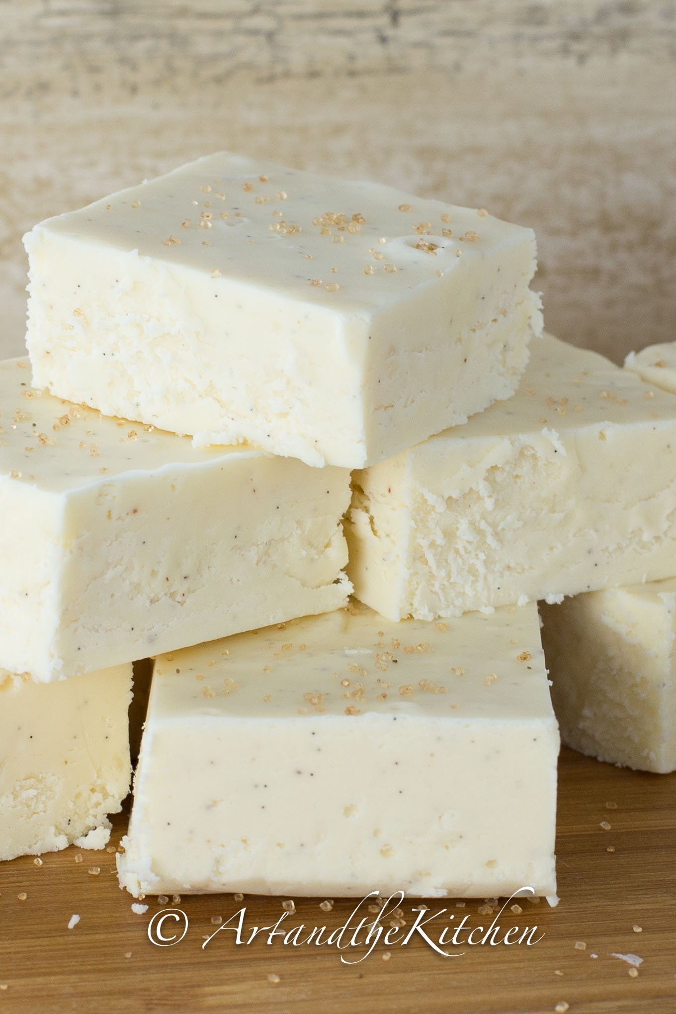 Stack of squares of white fudge made with eggnog flavor.