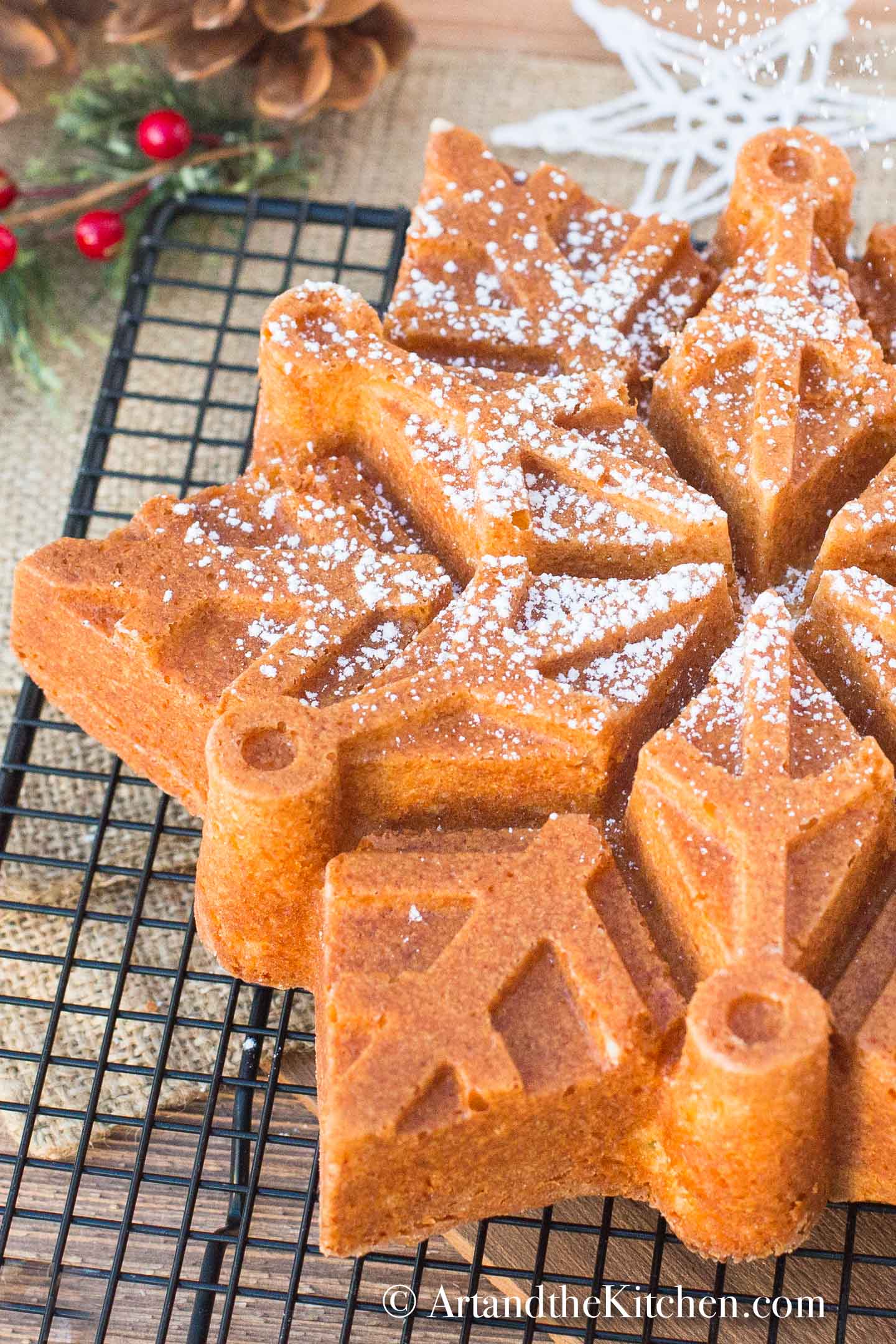 Snowflake shaped bundt cake made with eggnog, sprinkled with confectioners sugar.