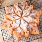 Snowflake shaped bundt cake made with eggnog, sprinkled with confectioners sugar.