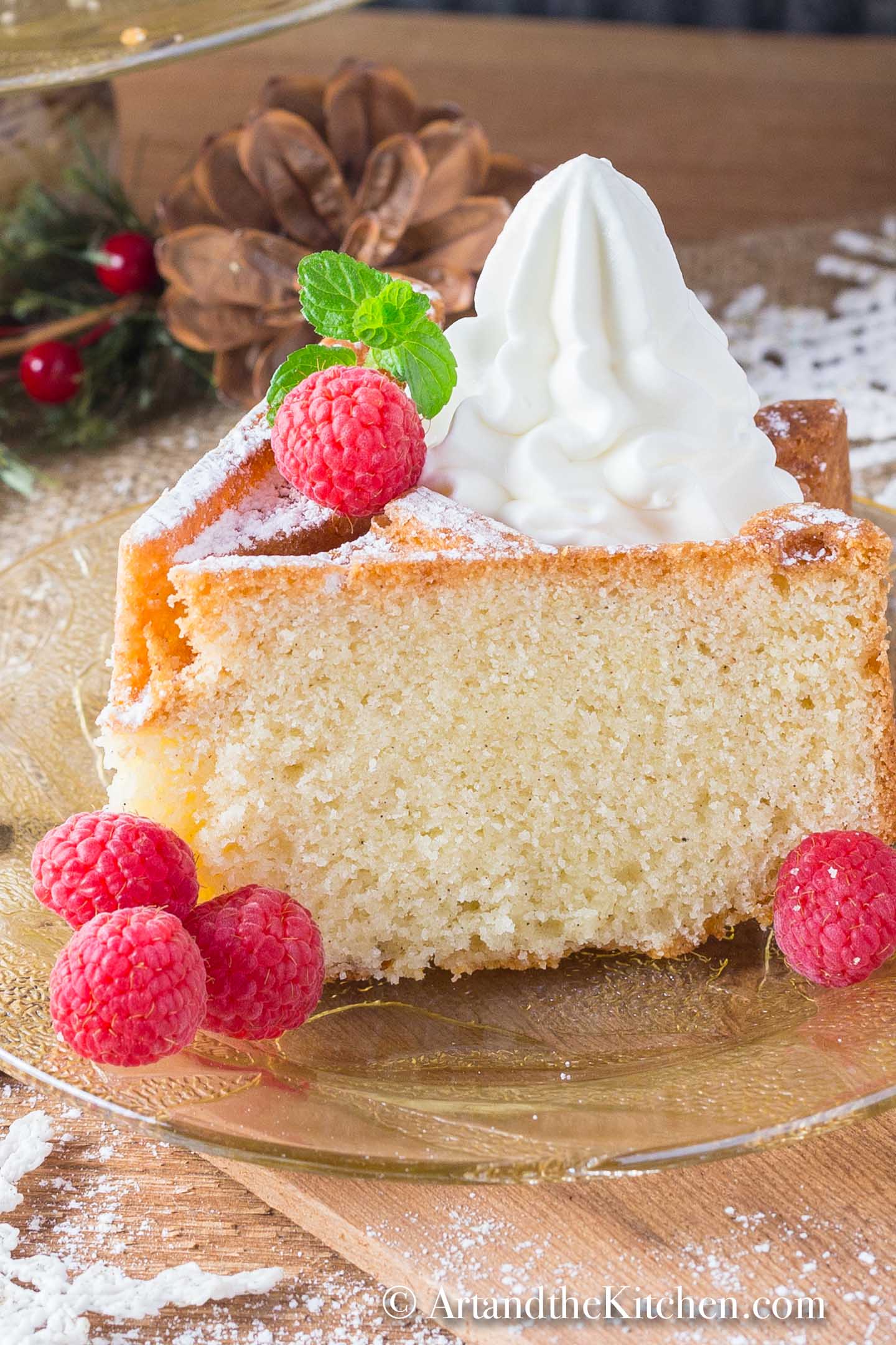 Slice of bundt cake made with eggnog, topped with whipped cream and fresh raspberries.