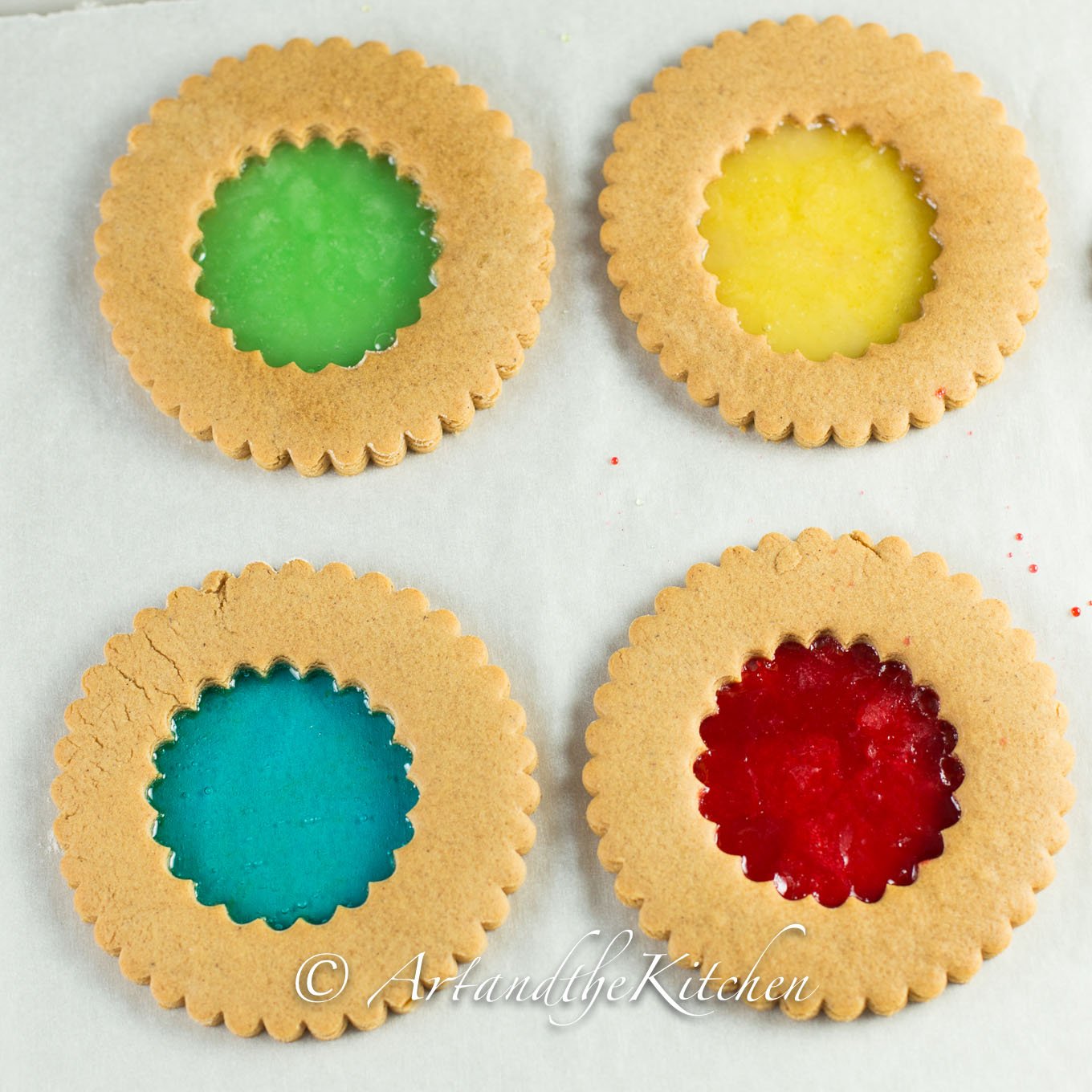 Four circle cookies with colourful stained glass looking centers.