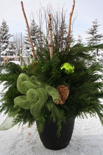 Outdoor Christmas planter with greenery , green bow and pinecones.