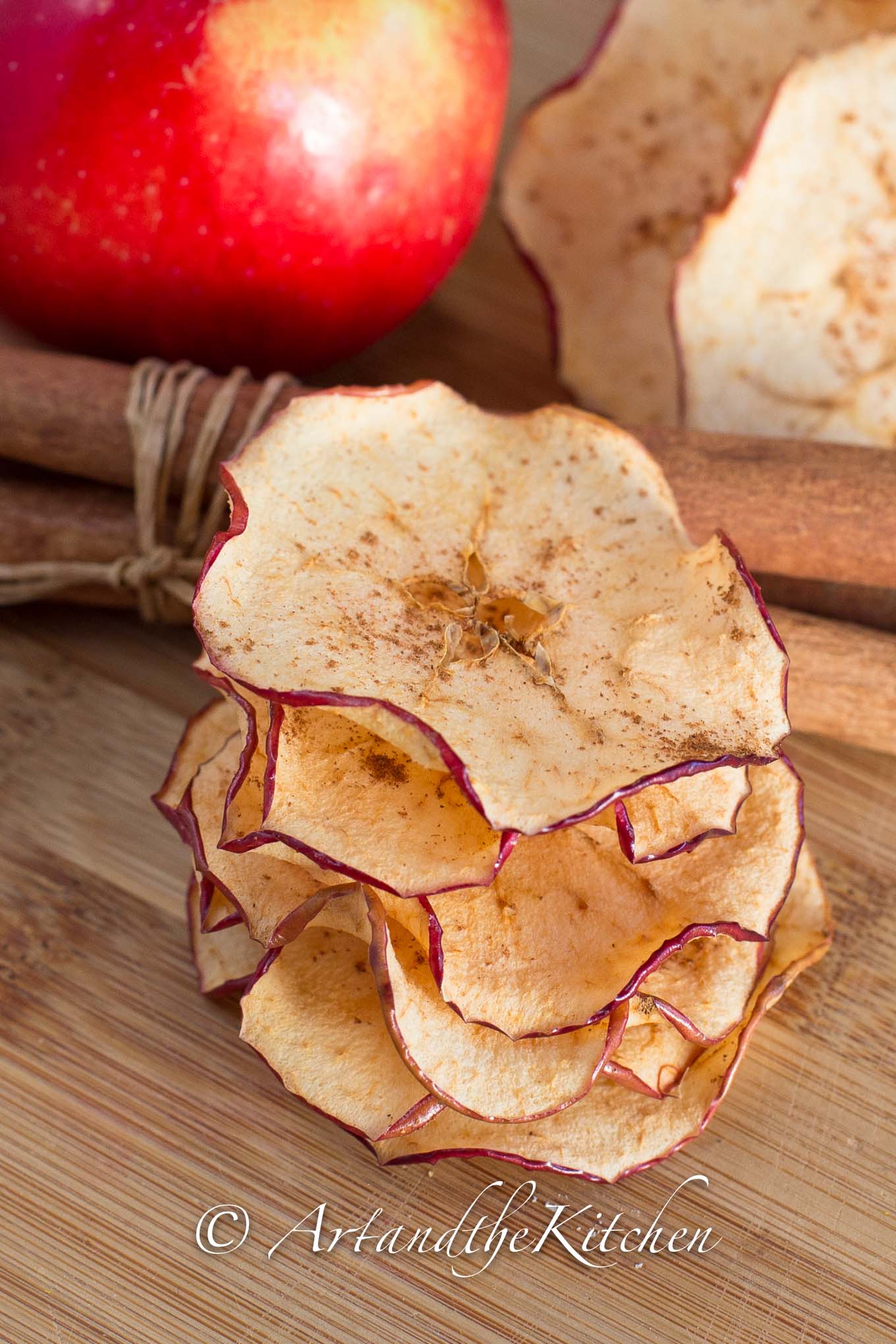 Stack of crisp apple chips sprinkled with cinnamon.