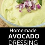 Avocado dip garnished with red onions, lime slice and cilantro in small glass bowl.