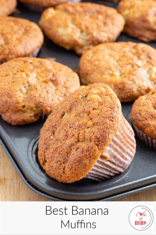 Muffin tin full of banana muffins with golden brown tops.