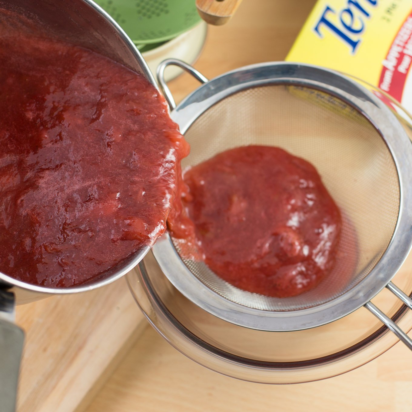 Strawberry rhubarb puree poured into strainer.