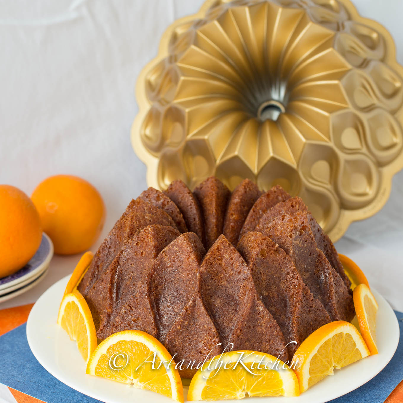 Orange flavored bundt cake decorated with fresh orange slices.