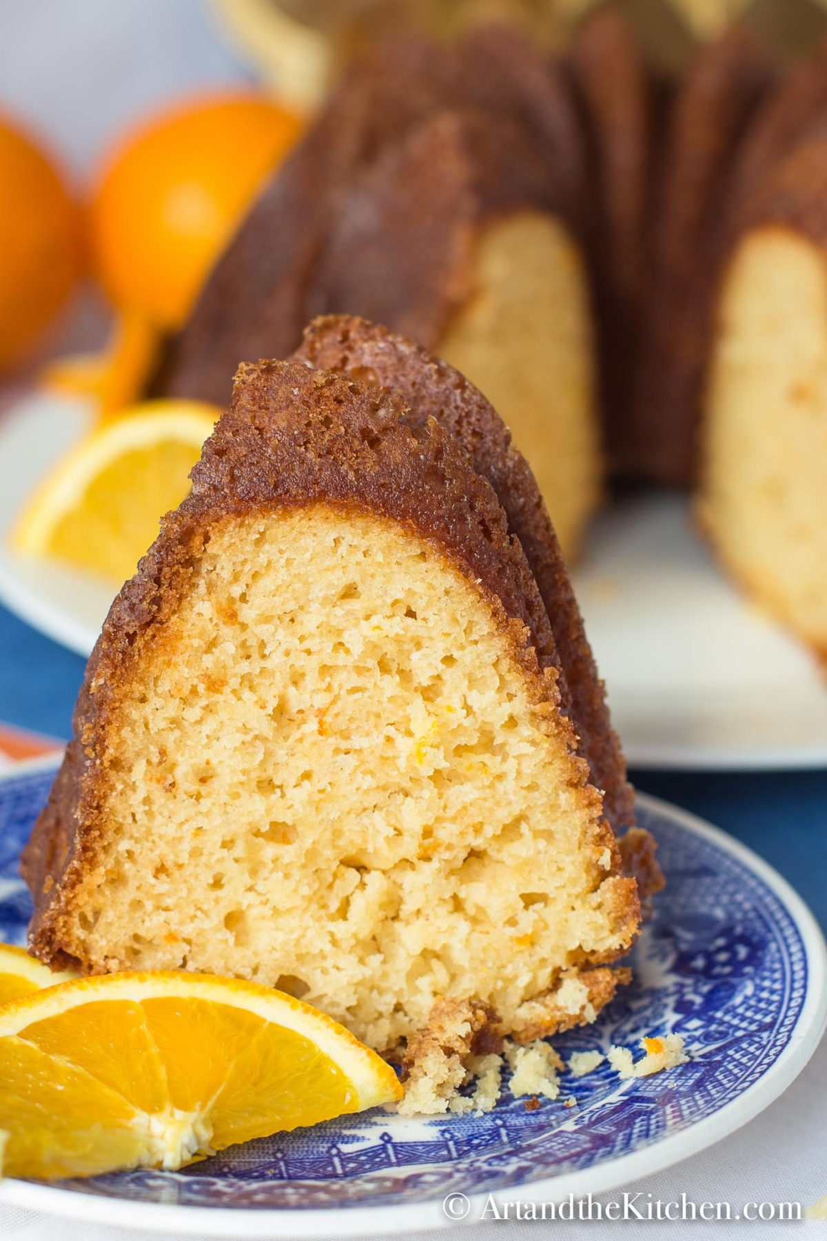 Slice of orange flavored cake decorated with orange slices.