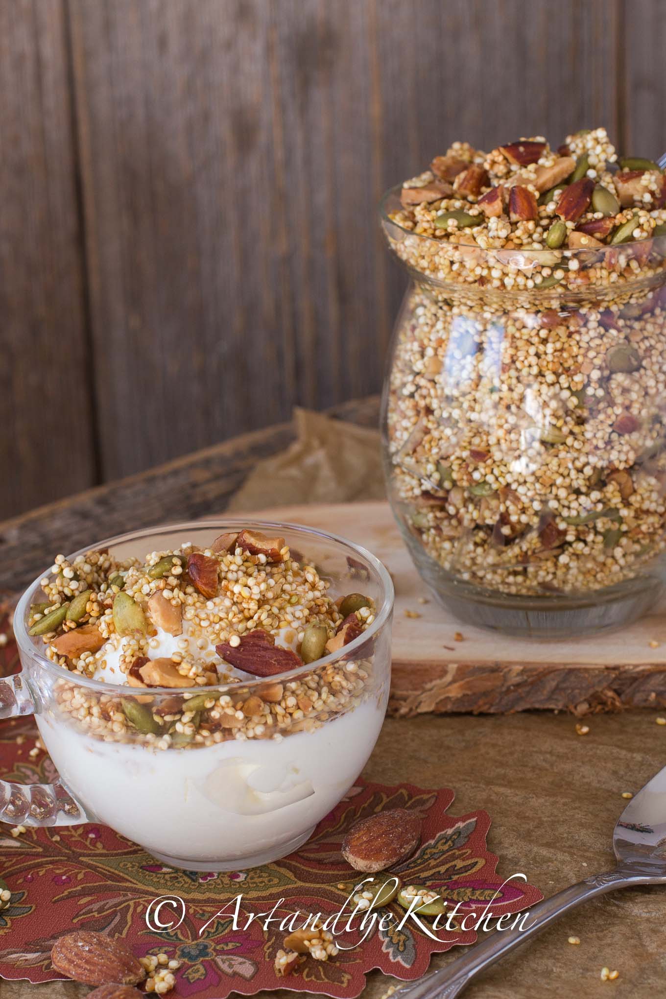 Glass bowl of yogurt topped with quinoa granola.