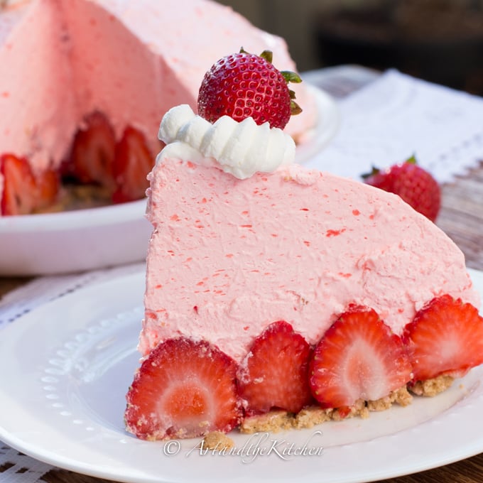 Slice of tall no-bake strawberry pie with fresh strawberries.