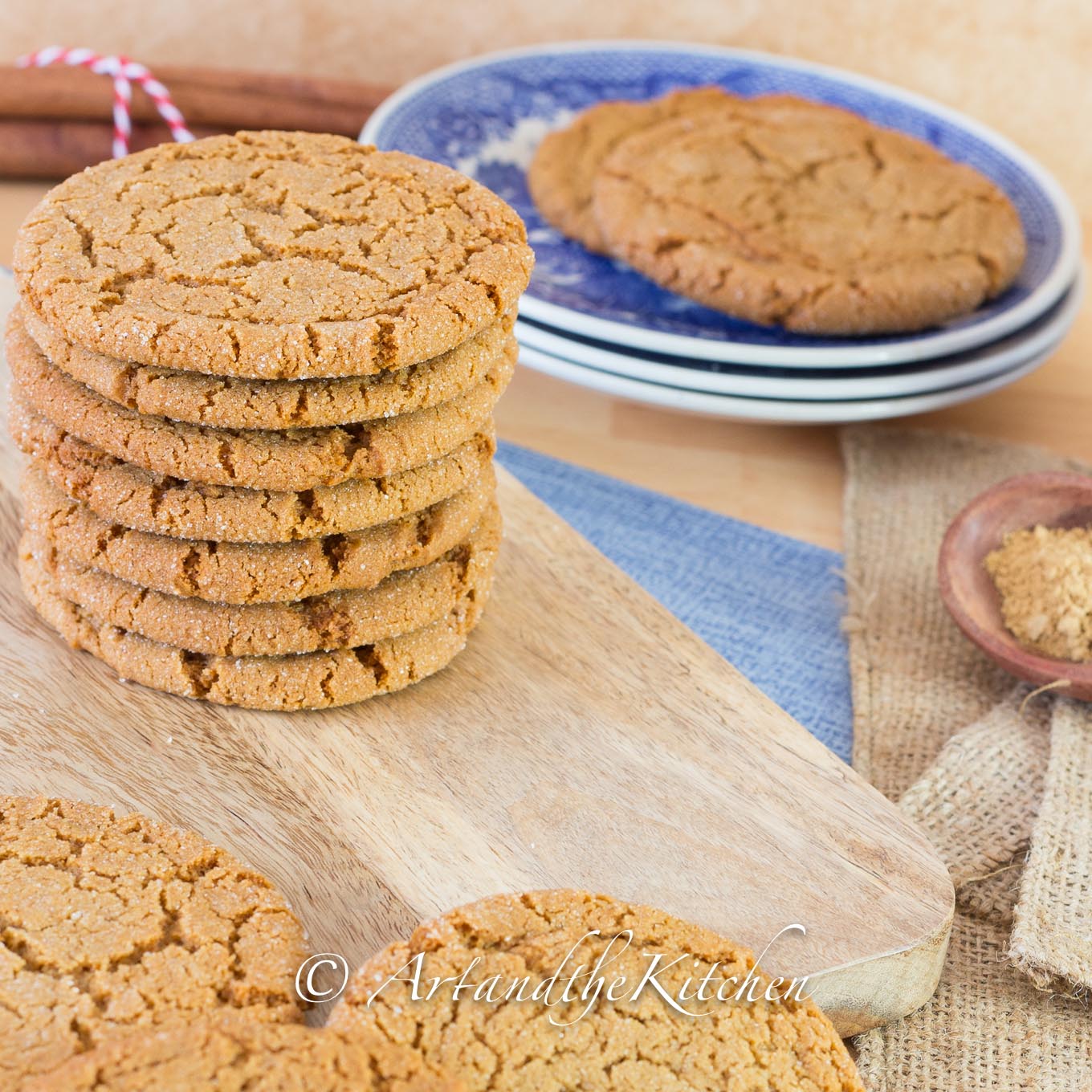 Stack of brown cookies made with ginger on wood board and blue plates