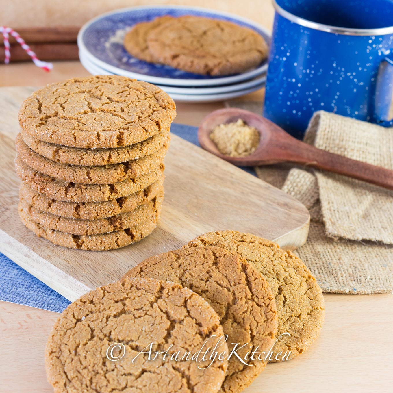 Ginger cookies on wood board with blue coffee mug and dishes.