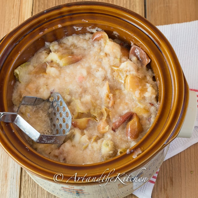 Slow cooker filled with mashed cooked apples.