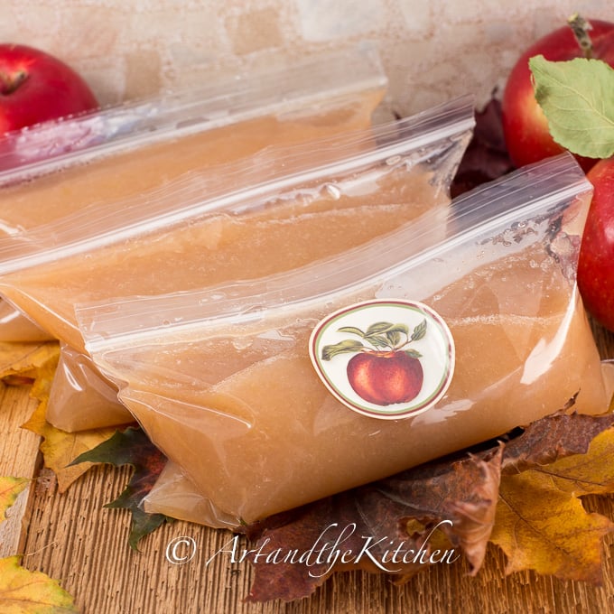 Small sized freezer bags labeled with apple sticker filled with applesauce.