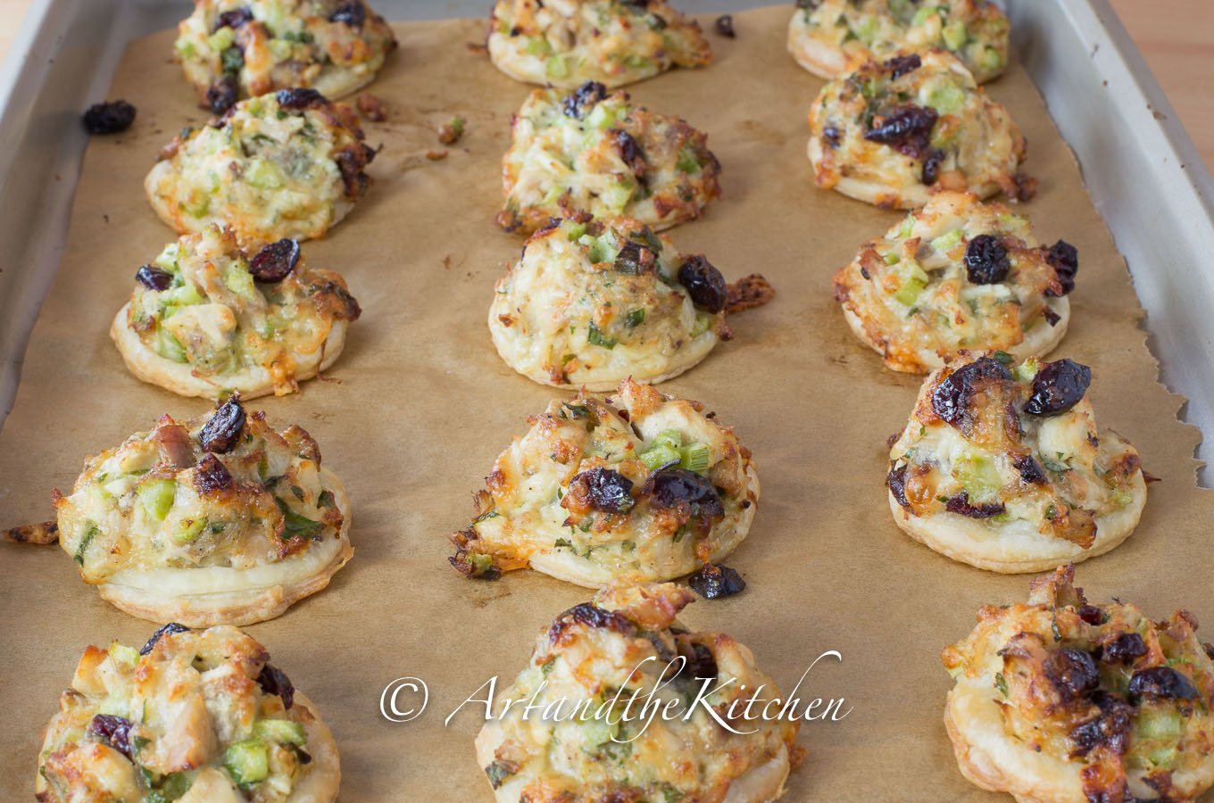 Bites of puffed pastry topped with turkey salad mix and cranberries.