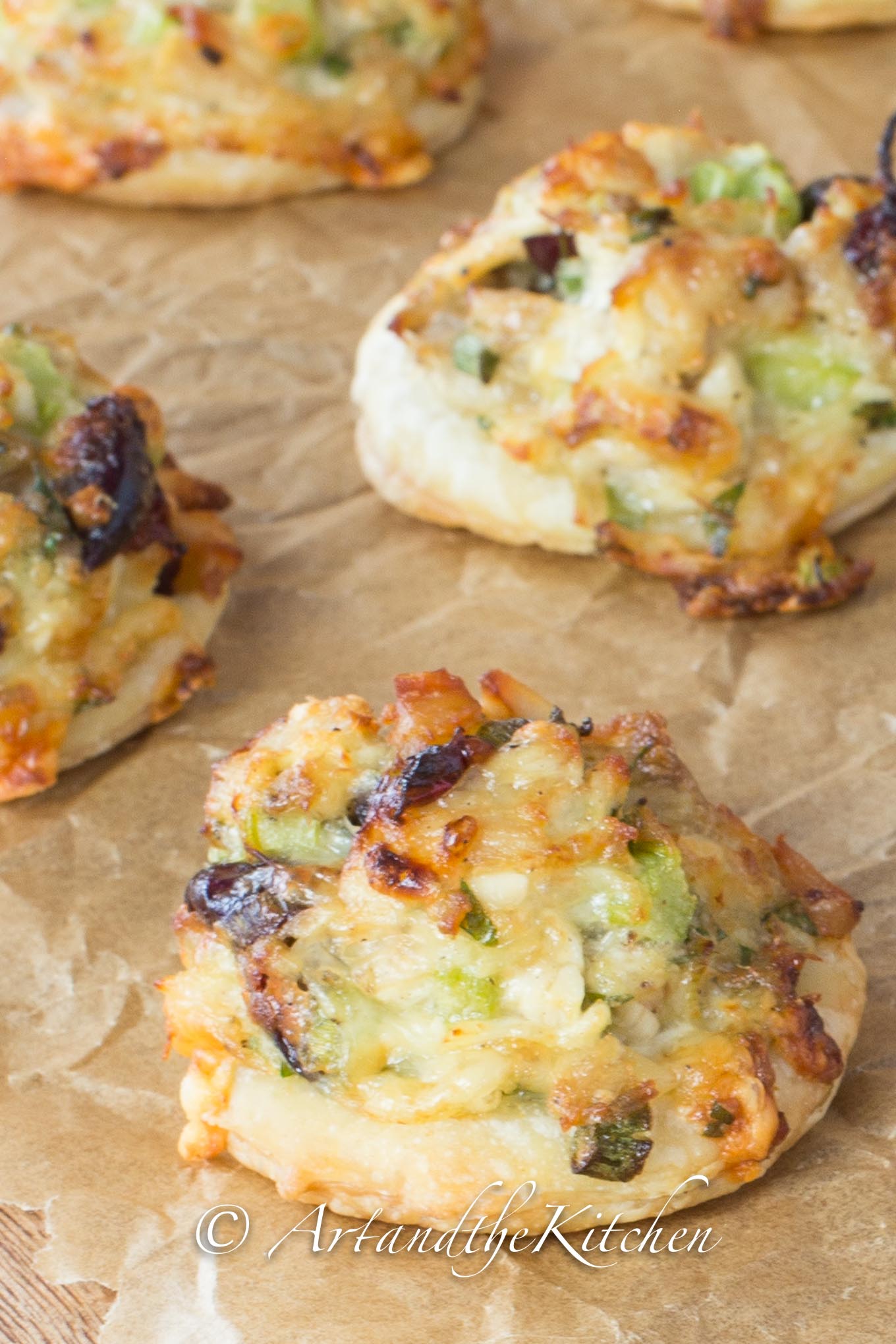 Bites of puffed pastry topped with turkey salad mix and cranberries.