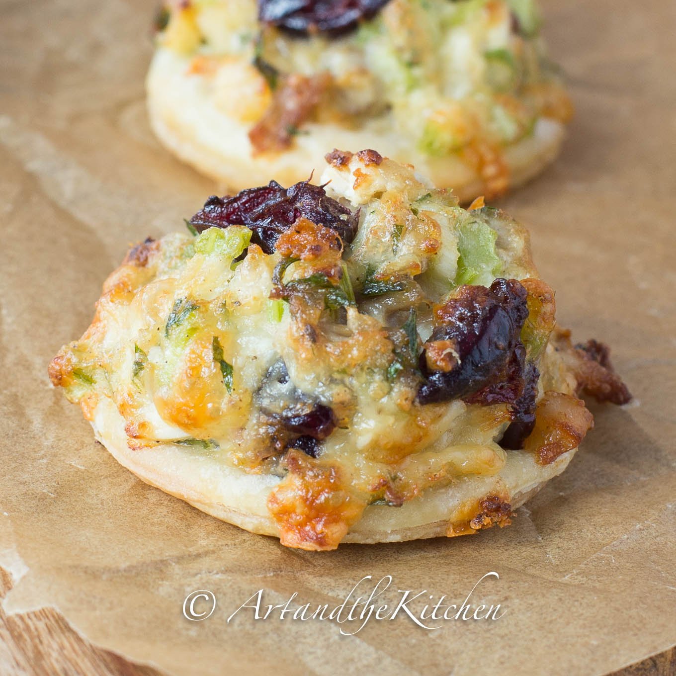 Bites of puffed pastry topped with turkey salad mix and cranberries.