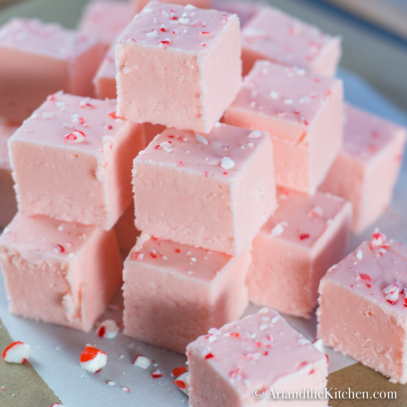 Stack of pink fudge made with ground up candy canes.