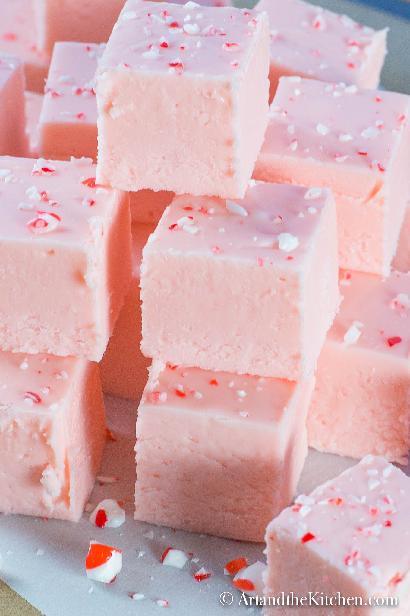 Stack of pink fudge made with ground up candy canes.