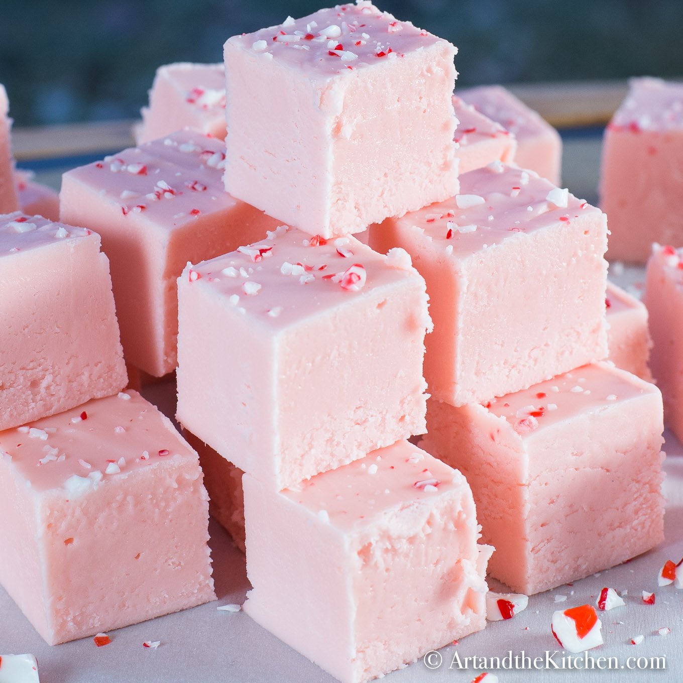 Stack of pink fudge made with ground up candy canes.