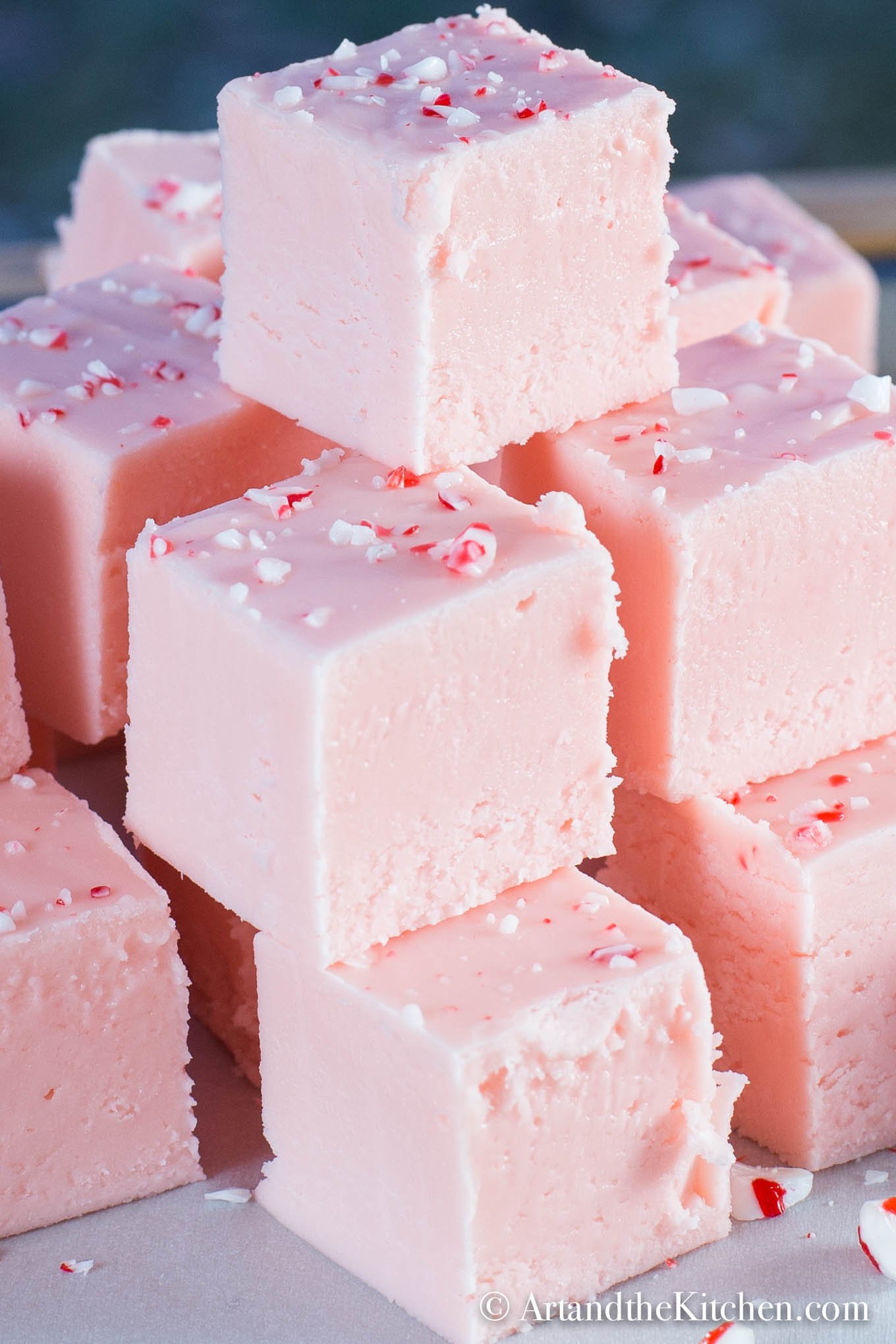 Stack of pink fudge that is made with candy cane sugar.
