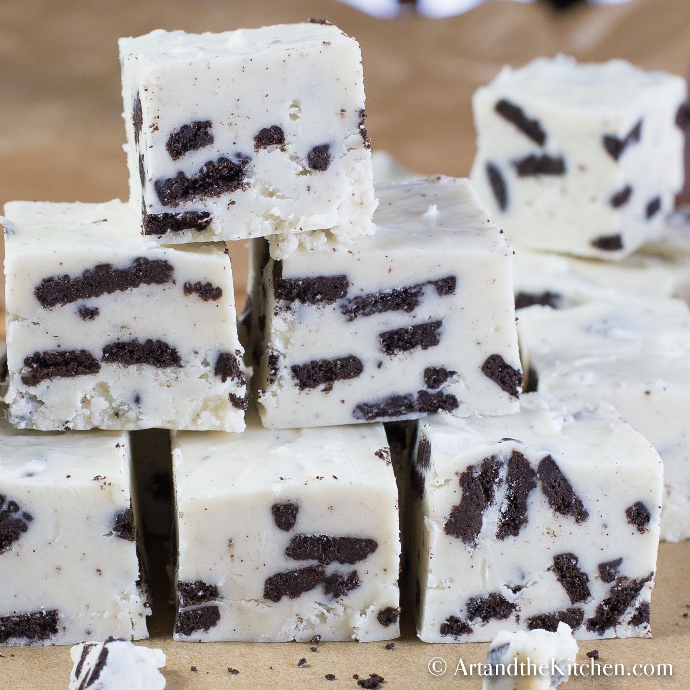 Stacked cubes of fudge made with white chocolate and Oreo cookie pieces.