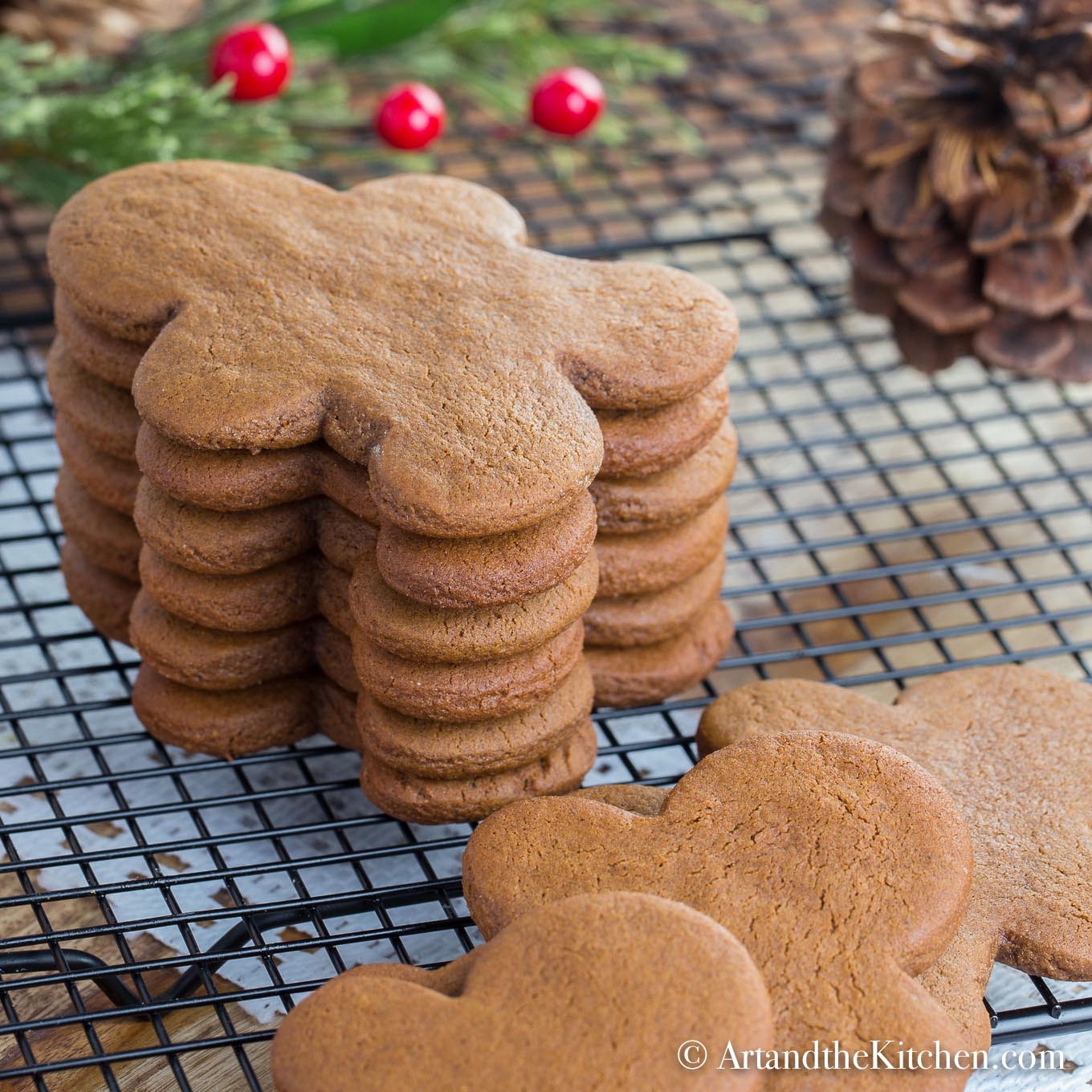 Stack of gingerbread men cookies on black cooling rack.