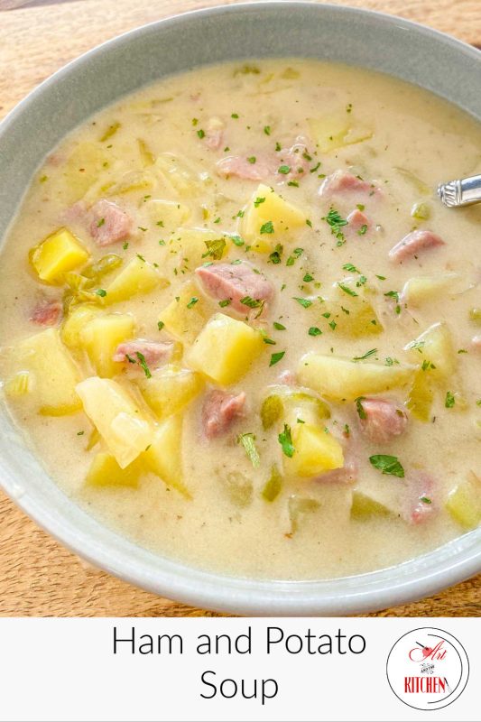 Creamy soup of potatoes and ham in a blue bowl.