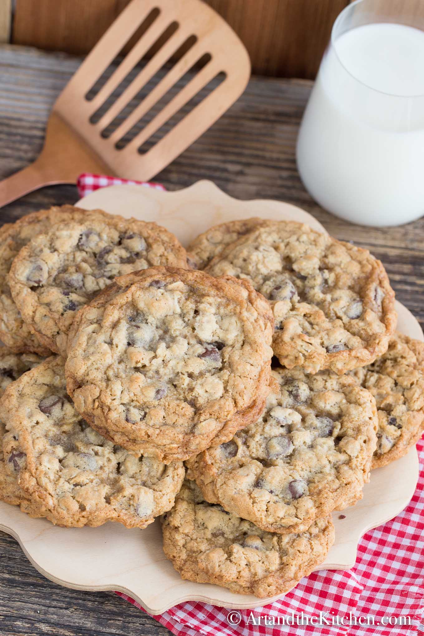 Wooden plate filled with homemade chocolate chip cookies with a glass of milk.