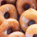 Rows of homemade plain donuts sprinkled with sugar.