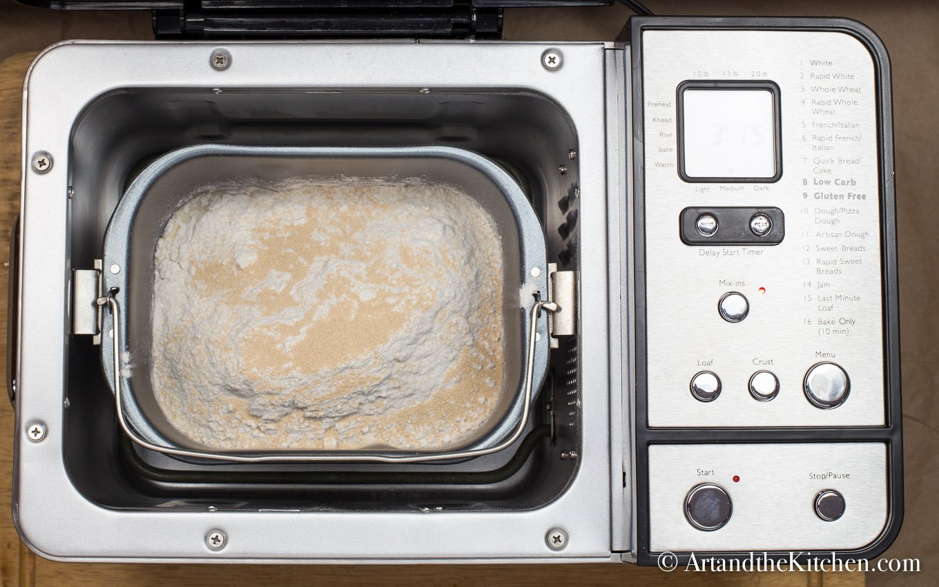 Bread machine filled with ingredients for making donuts.