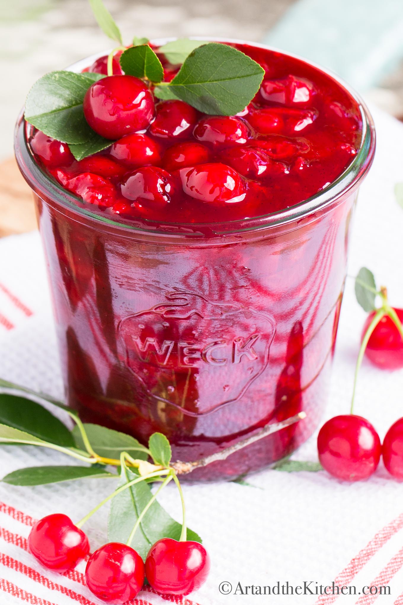 Glass jar filled with cherry sauce.