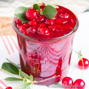 Glass jar filled with cherry sauce.