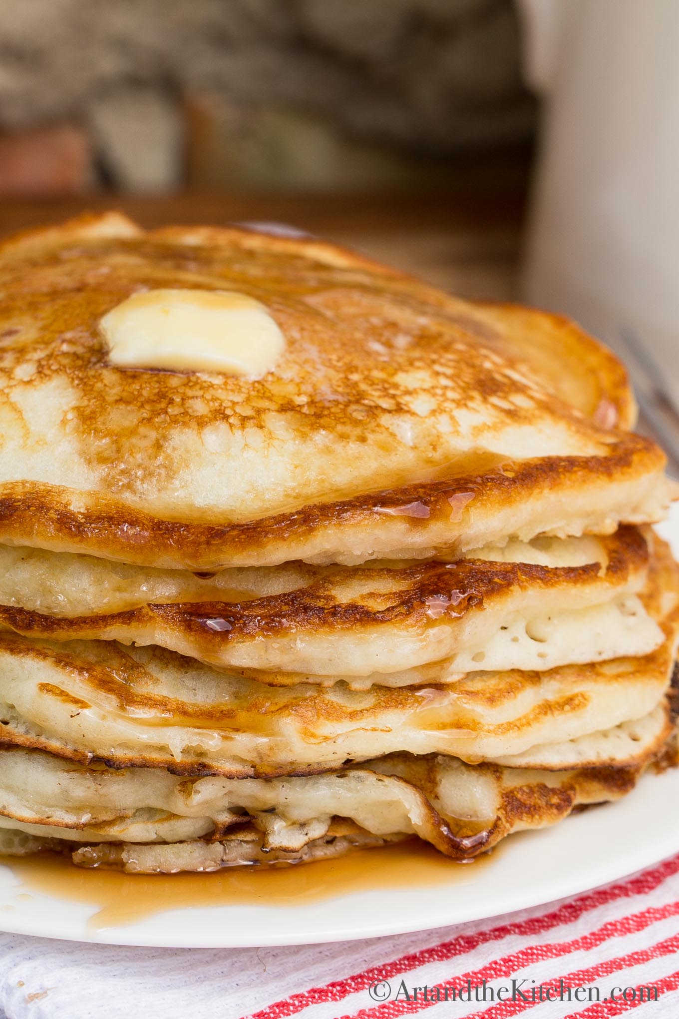 stack of pancakes with dollop of butter and syrup on top