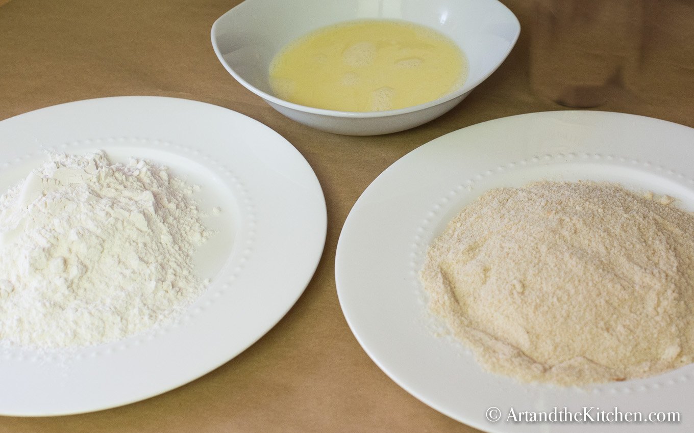 Bowls of flour, beaten egg/milk and bread crumbs.