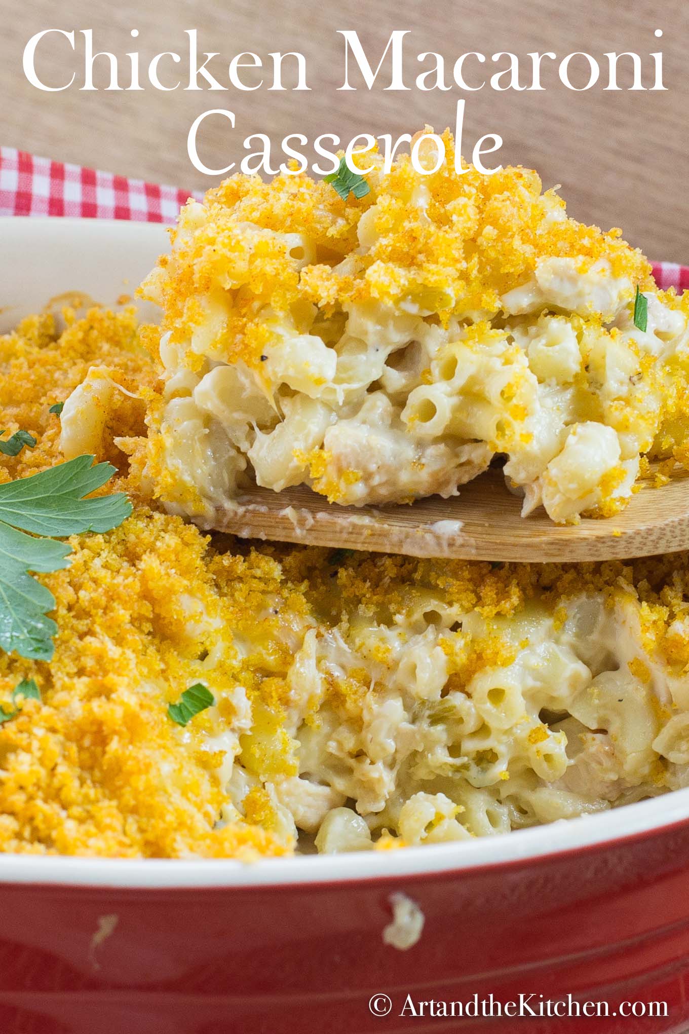 Macaroni casserole with cubes of chicken, golden brown panko bread crumb topping. Served in red stoneware baking dish.