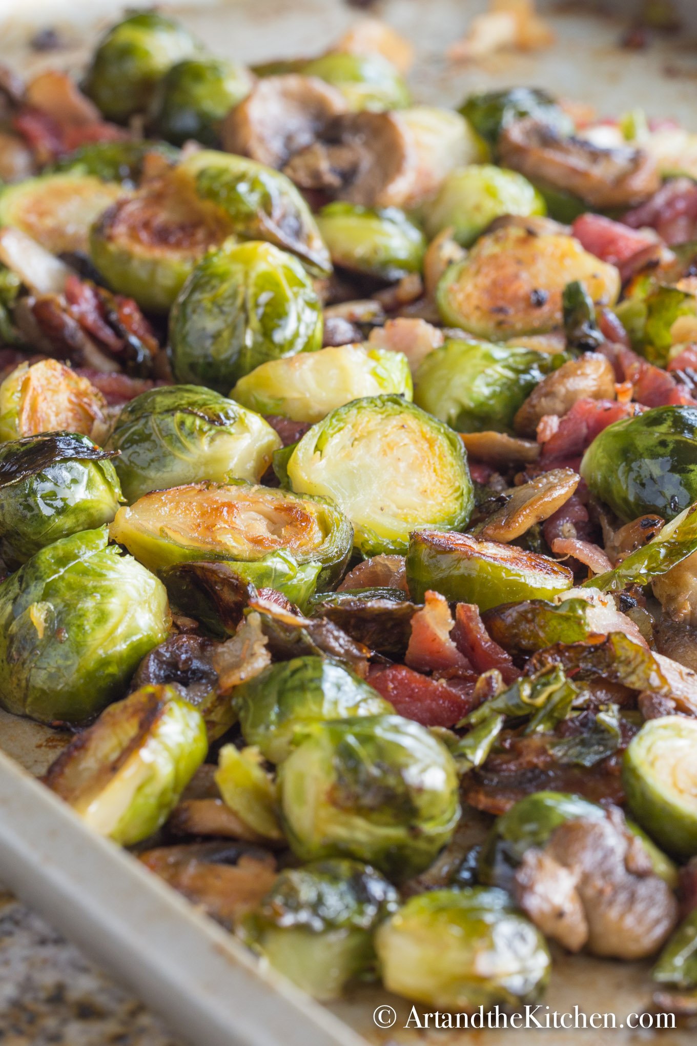 Baking sheet of roasted brussels sprouts, bacon and mushrooms.