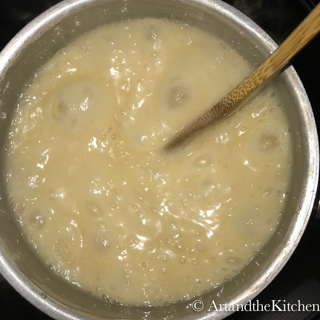 Butter, cream and sugar boiling in cooking pot.