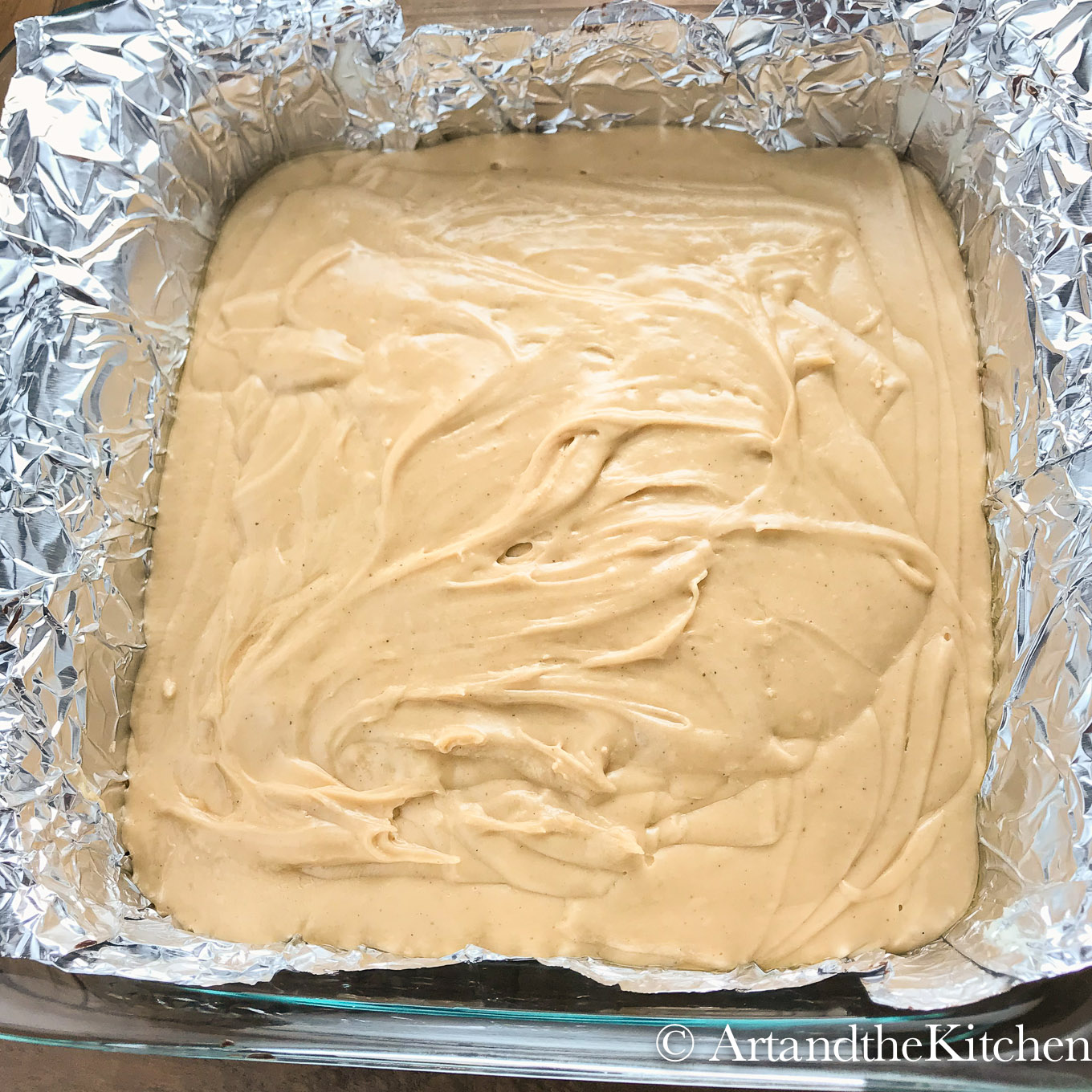 Peanut butter fudge in foil lined glass baking dish.