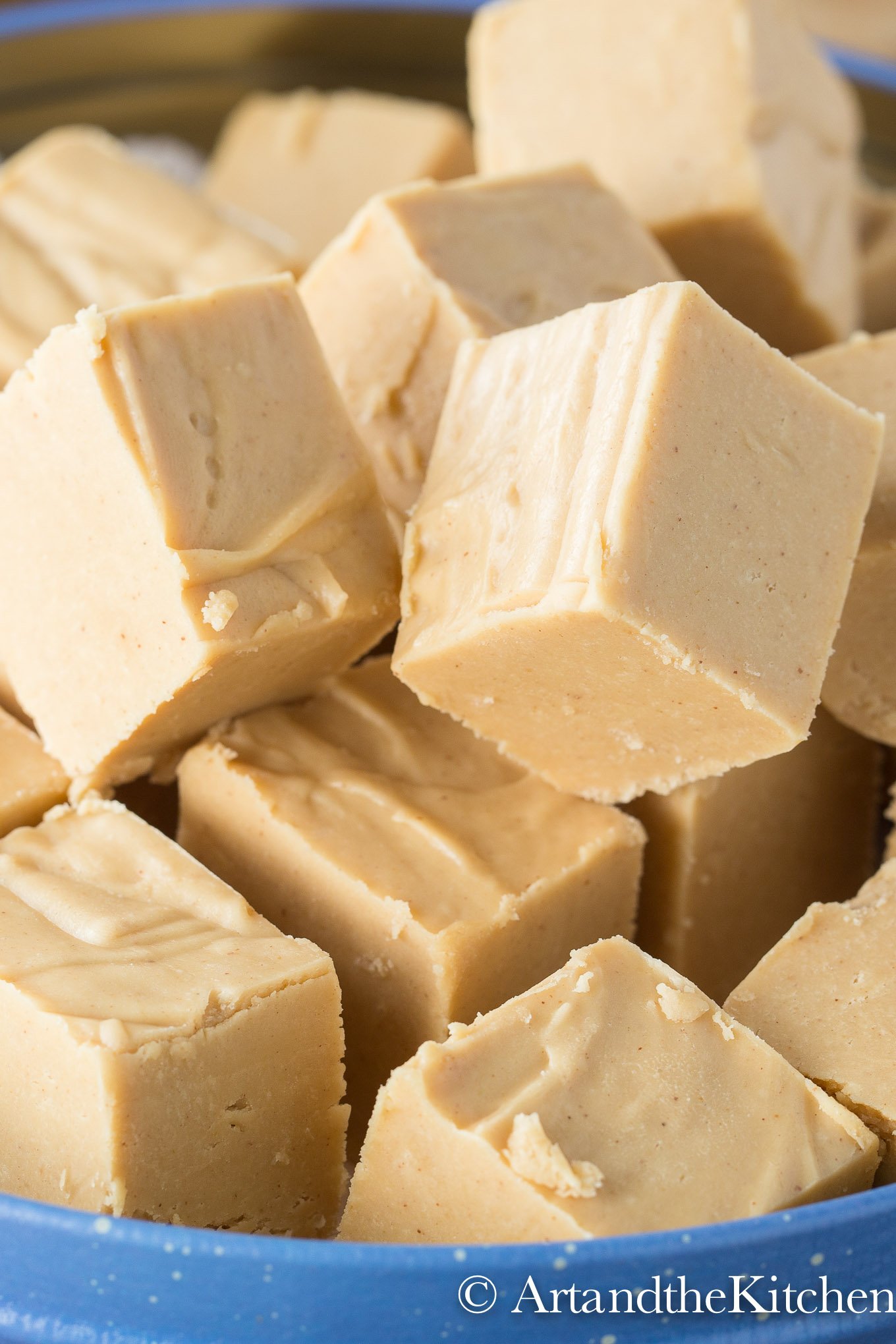 Blue container piled with cubes of peanut butter fudge.