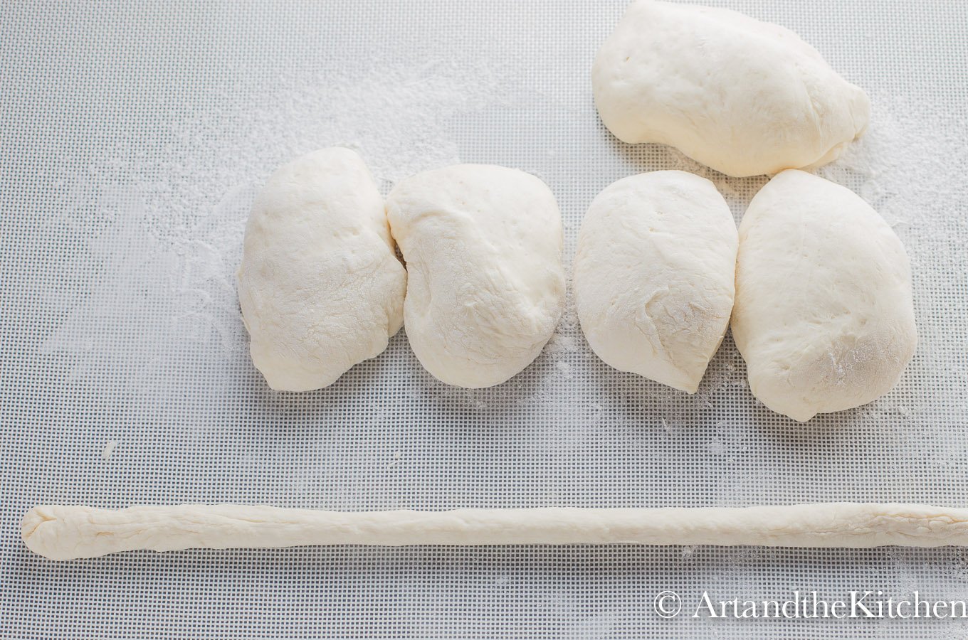 pretzel dough with four evenly cut pieces and one rolled out piece of dough