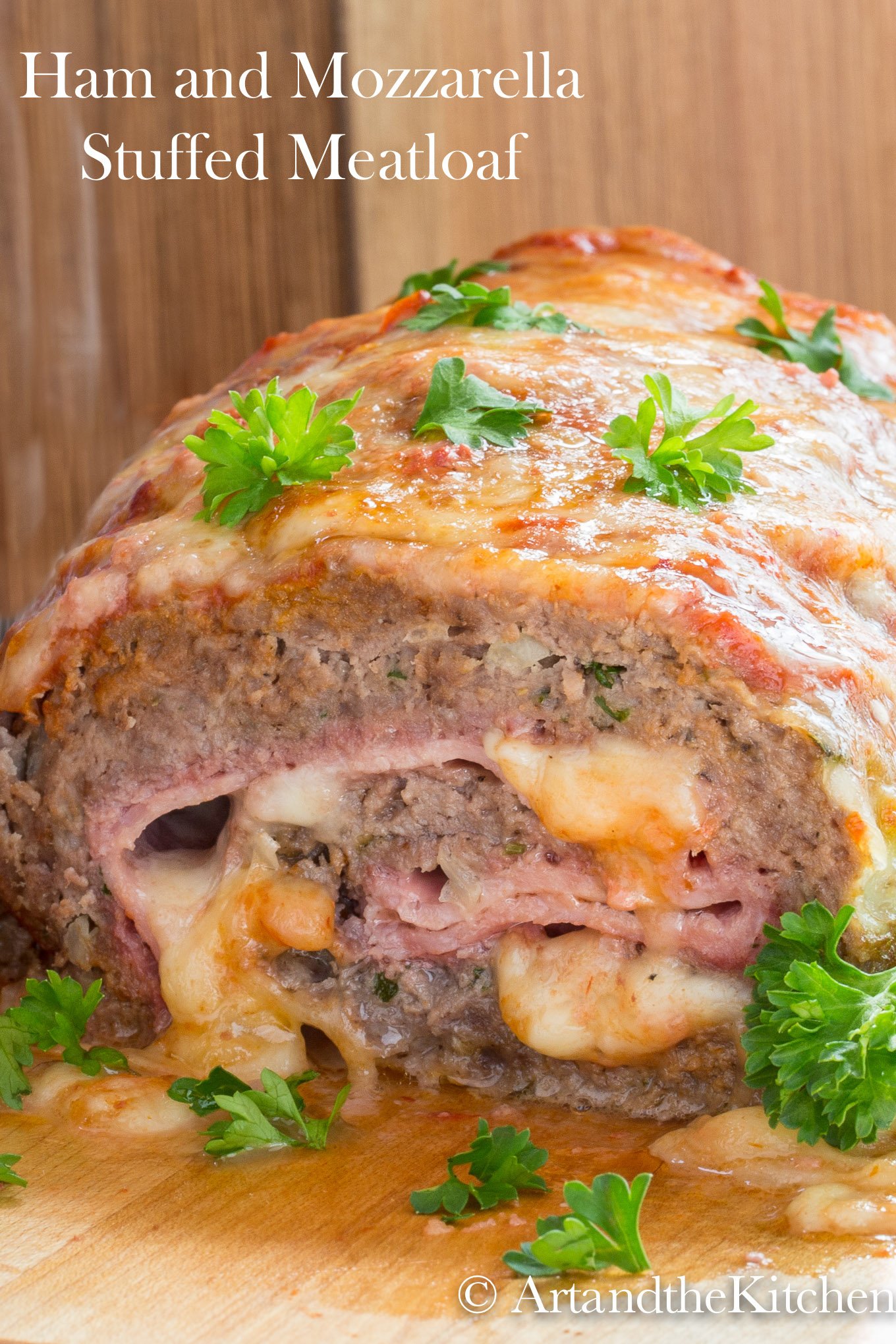 Meatloaf stuffed with ham and mozzarella cheese, garnished with parsley leaves.