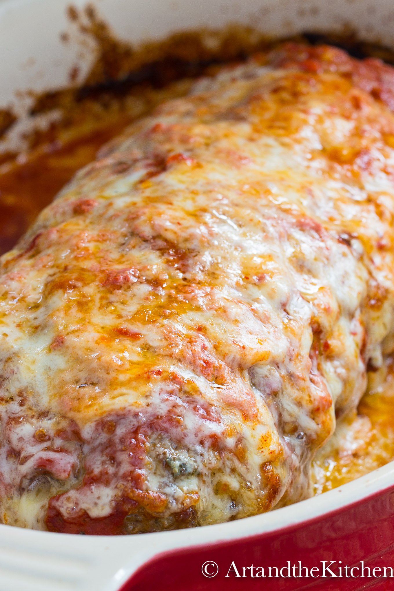 Meatloaf in baking dish covered with melted mozzarella cheese.