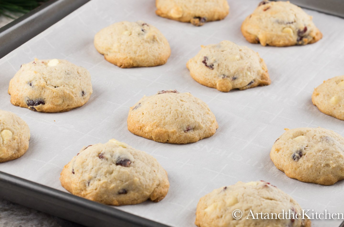 Fluffy baked cookies on baking sheet lined with white parchment paper.